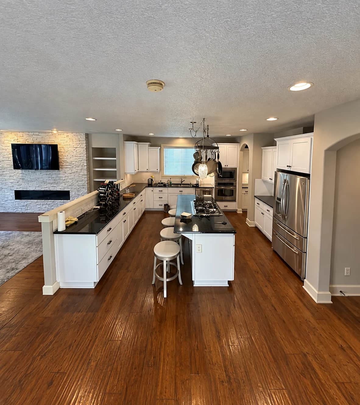 White cabinets and a kitchen island finished by Val Painting LLC