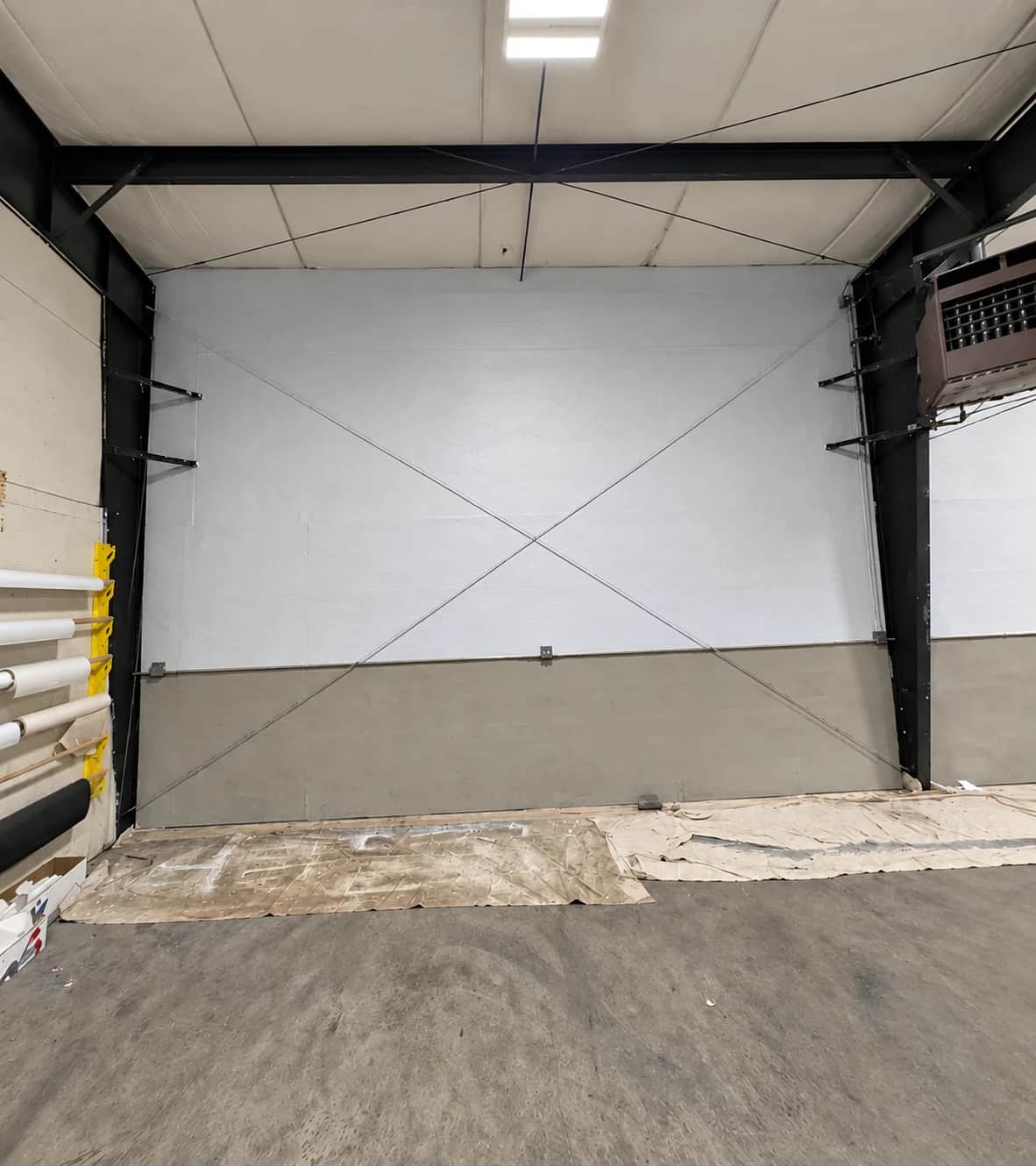 Commercial wall in Southwest Washington after repainting, with a white upper section, taupe lower section and black steel beams.